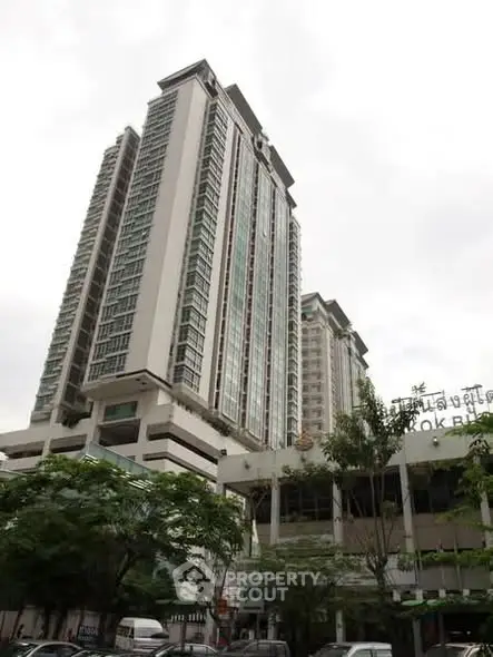 Stunning high-rise building with modern architecture and lush greenery in urban setting.