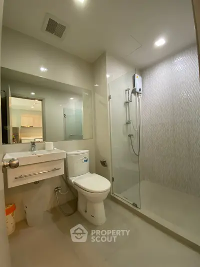 Modern bathroom with glass shower and sleek fixtures in a contemporary apartment.