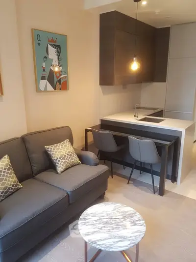 Modern living room with stylish kitchen and cozy seating area in a contemporary apartment.