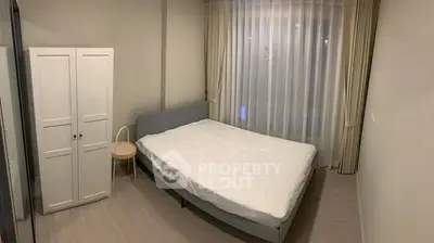 Cozy bedroom with minimalist design and ample natural light.