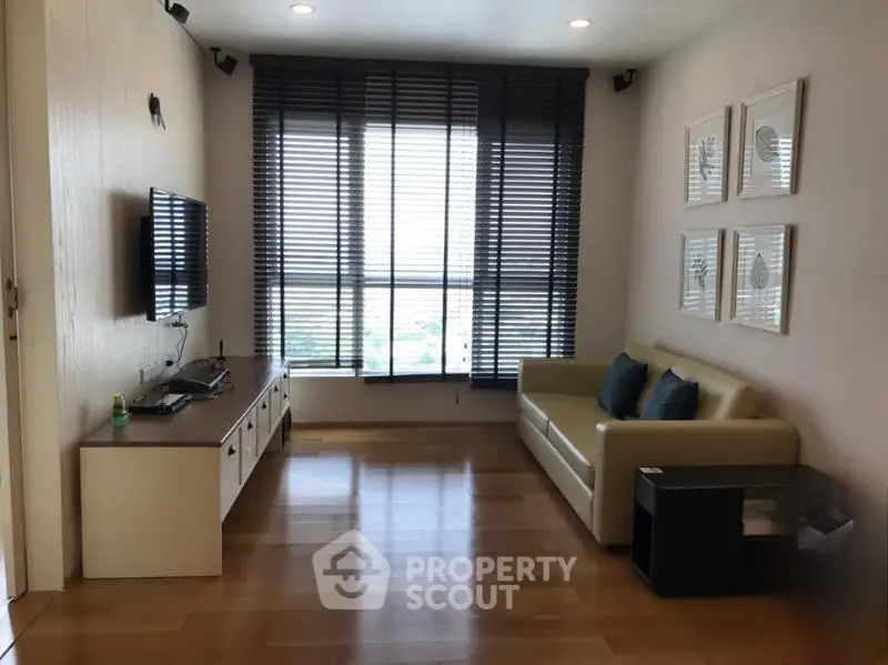 Modern living room with sleek furniture and large windows offering natural light.