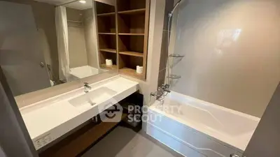Modern bathroom with sleek fixtures and spacious bathtub in contemporary apartment.