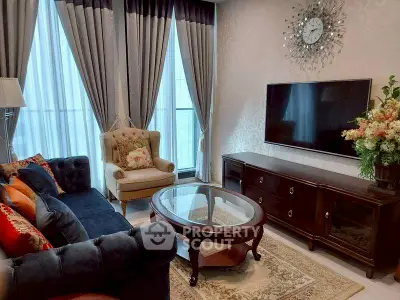 Elegant living room with plush sofa, armchair, and large TV, perfect for relaxation.