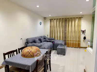 Spacious living room with cozy gray sofa and dining area, perfect for family gatherings.