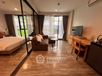 Modern studio apartment with glass partition, cozy living area, and garden view.