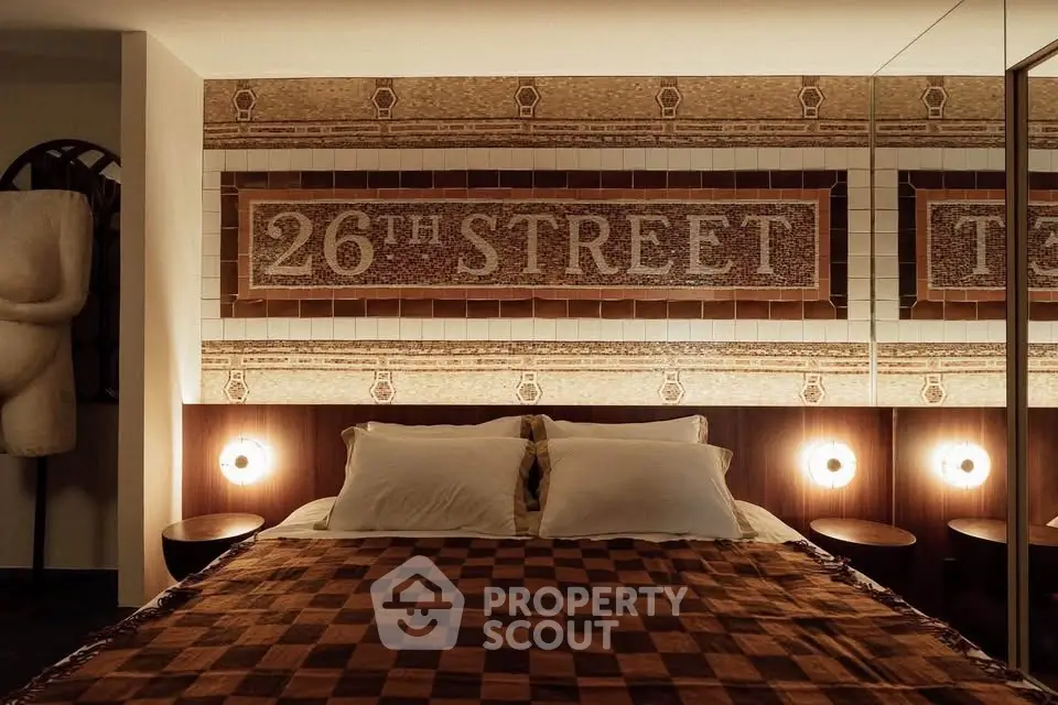 Cozy bedroom with unique 26th Street wall art and warm lighting