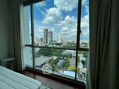 Stunning cityscape view from a modern high-rise apartment bedroom window.