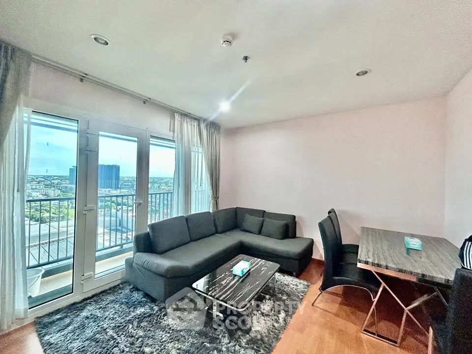 Modern living room with city view, featuring sleek furniture and a cozy atmosphere.