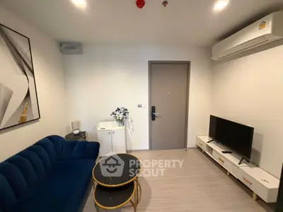 Modern living room with blue sofa, TV, and air conditioning