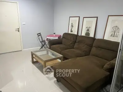 Cozy living room with brown sectional sofa, glass coffee table, and decorative wall art.
