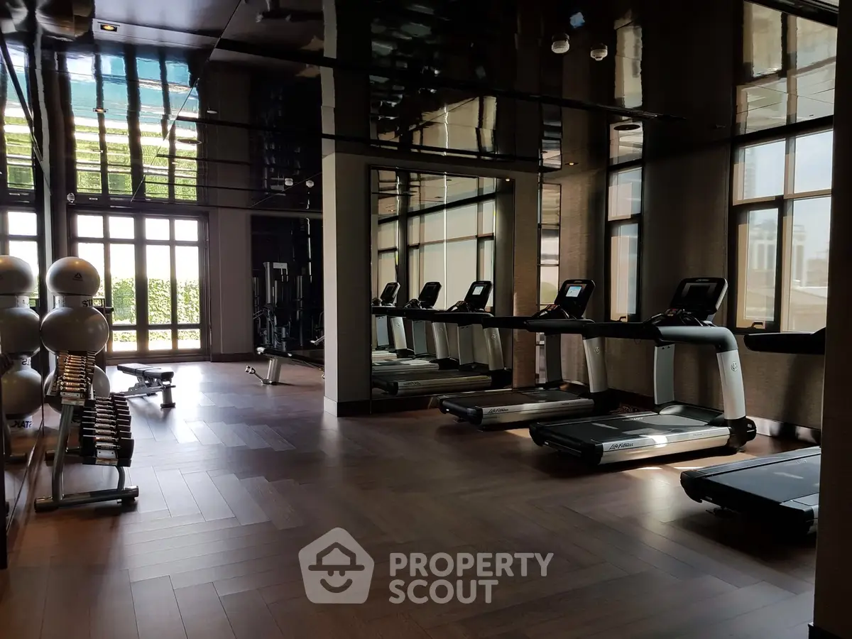 Luxurious gym with modern equipment and large windows in upscale property