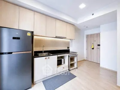 Modern kitchen with sleek cabinetry and stainless steel appliances in a stylish apartment.