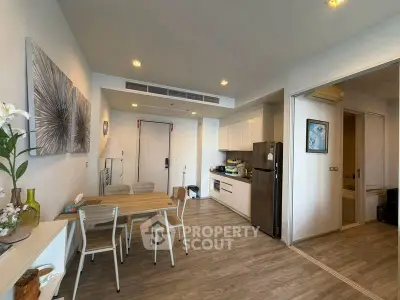Modern open-plan kitchen and dining area with stylish decor and wooden flooring.