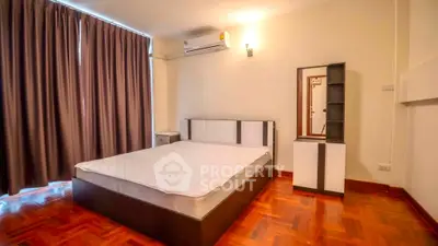 Spacious bedroom with modern furniture and elegant wooden flooring