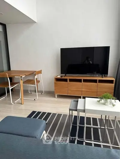 Modern living room with sleek furniture and large TV, perfect for relaxation and entertainment.