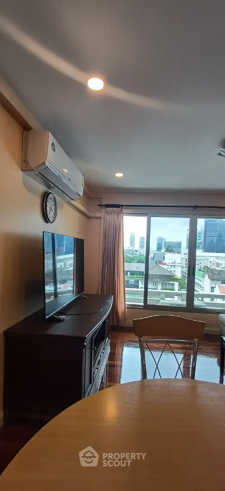 Spacious living room with city view and modern amenities in high-rise apartment.