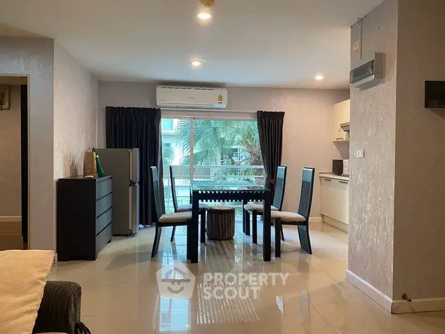 Spacious open-plan living and dining area with modern furnishings and large window view.