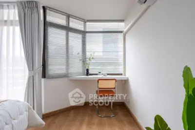 Bright study nook with modern chair and desk by large windows in a stylish apartment.