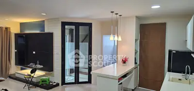 Modern open-layout living space with sleek kitchen and stylish lighting