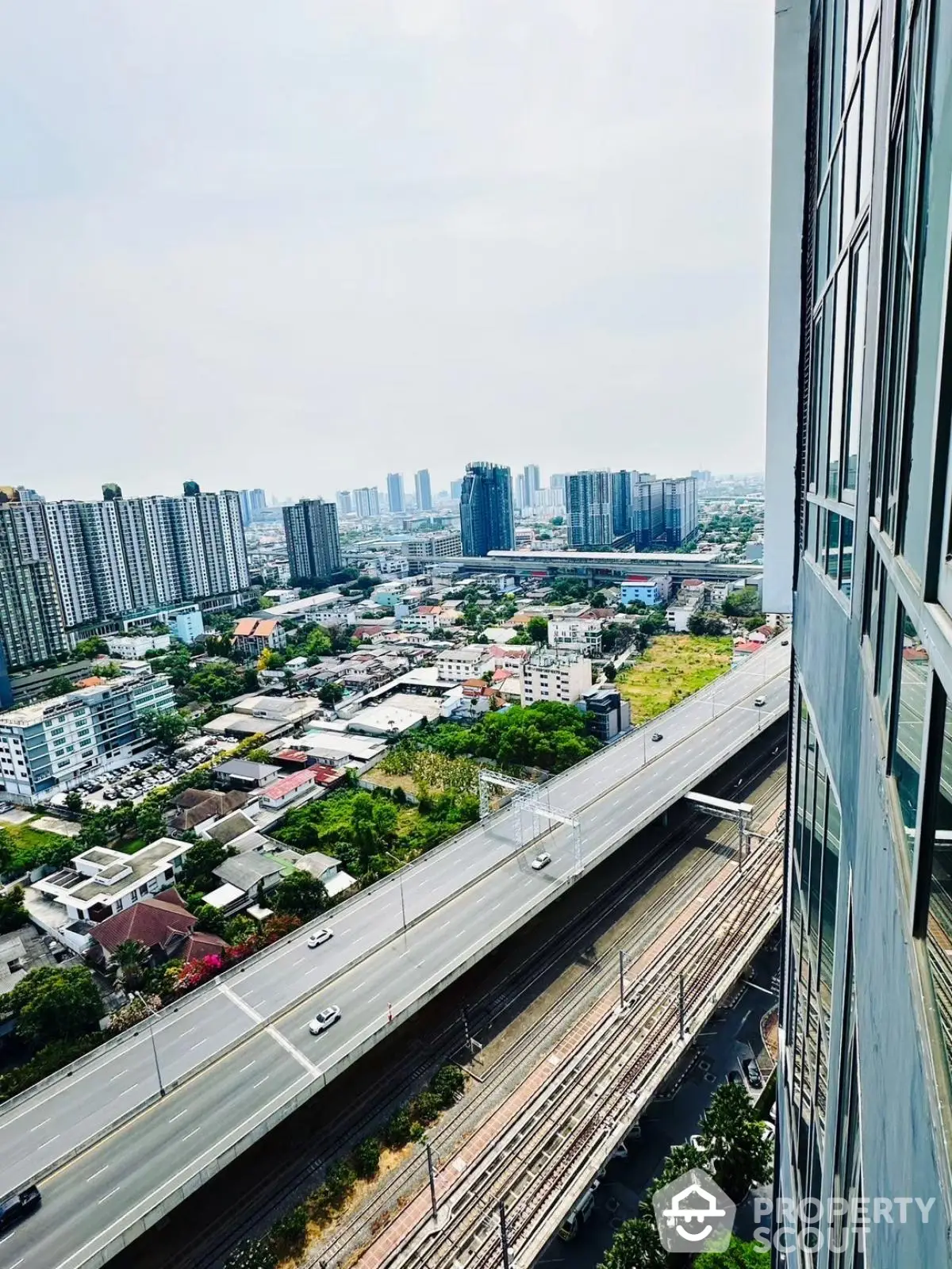 Stunning cityscape view from high-rise building overlooking urban skyline and highway.