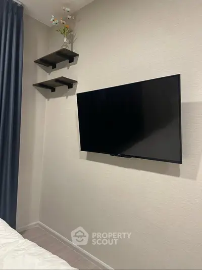 Modern bedroom with wall-mounted TV and stylish floating shelves