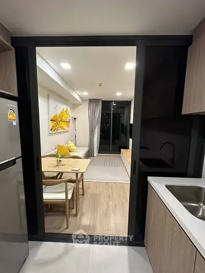 Modern open-layout kitchen and living room with sleek design and contemporary furnishings.