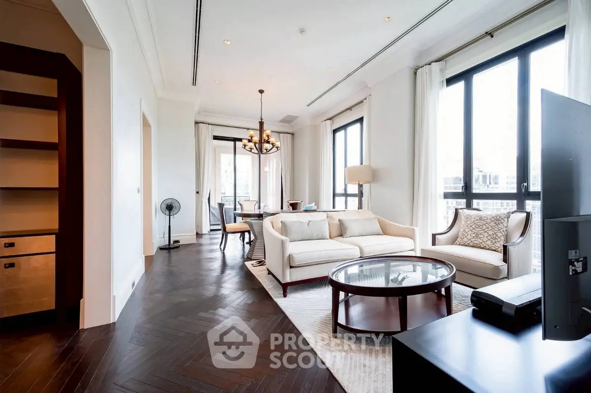 Luxurious living room with elegant decor and large windows offering city views.
