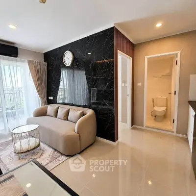 Modern living room with elegant sofa and marble accent wall, featuring a view of the balcony.