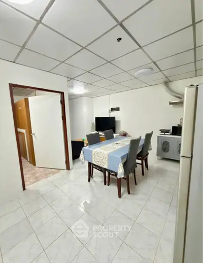 Spacious dining area with modern furniture and tiled flooring in a cozy apartment.