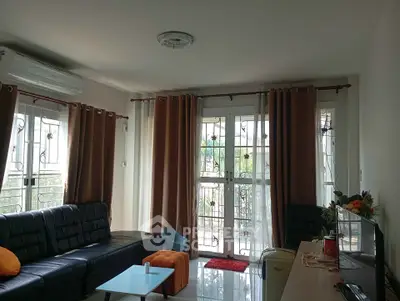 Spacious living room with modern decor and large windows offering natural light.