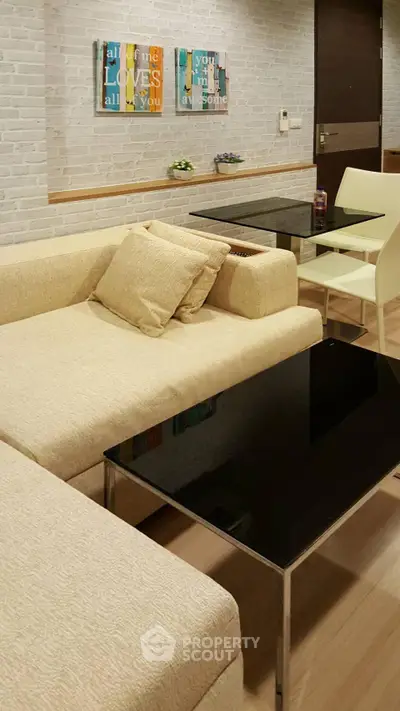 Modern living room with beige sofa and sleek black coffee table in stylish apartment.