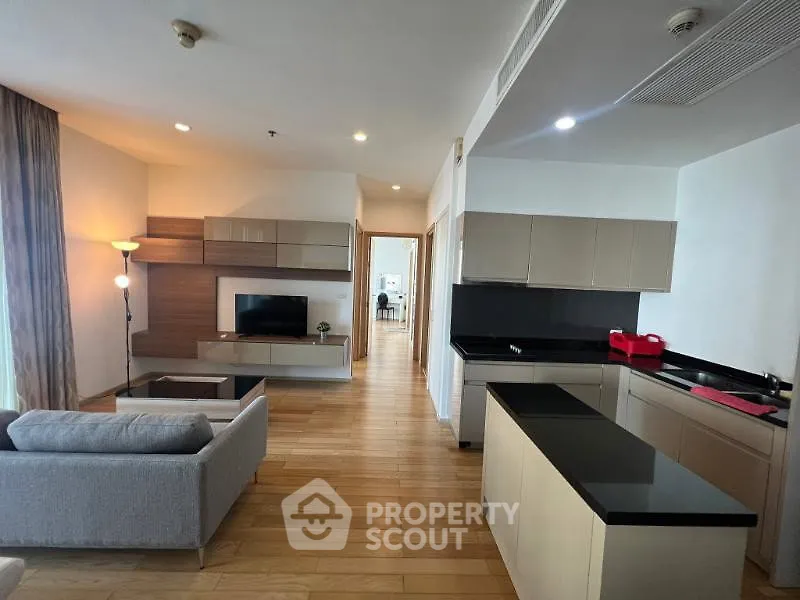 Spacious modern living room with open kitchen and sleek wooden flooring