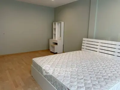 Spacious bedroom with modern bed frame and wooden flooring