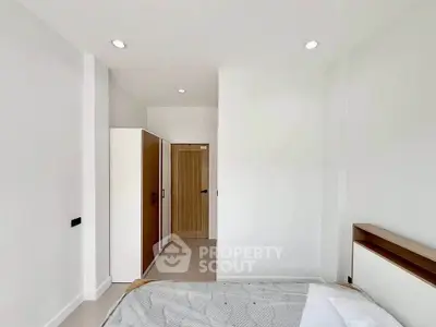 Modern minimalist bedroom with sleek design and ample natural light.