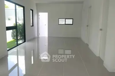 Spacious modern living room with glossy tiled floors and large windows.