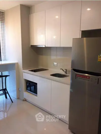 Modern kitchen with sleek cabinetry and stainless steel appliances in a compact layout.