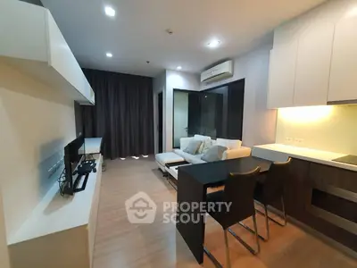 Modern living room with open kitchen, sleek furniture, and ambient lighting in a stylish apartment.