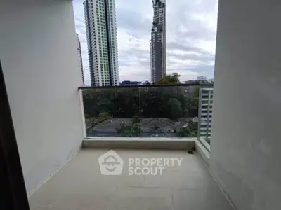 Spacious balcony with stunning cityscape view in modern high-rise apartment.