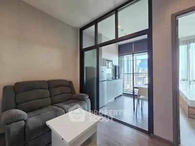 Modern apartment interior with cozy living room and open kitchen layout, featuring a balcony view.