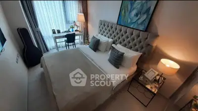 Elegant bedroom with plush headboard, cozy bedding, and a stylish desk by the window.