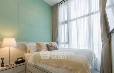 Modern bedroom with large windows and elegant decor in a high-rise apartment.