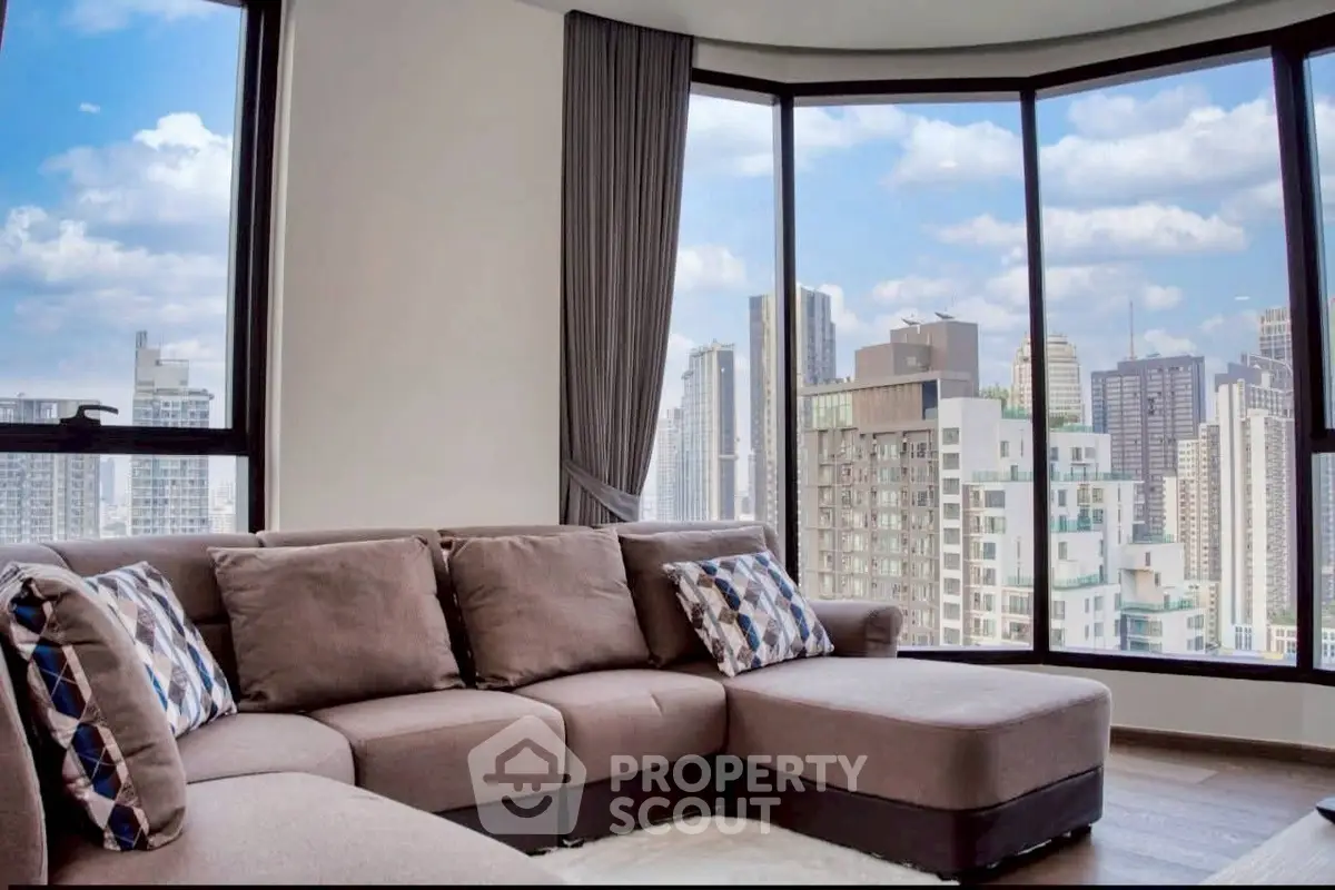 Luxurious living room with panoramic city views and stylish sectional sofa in modern high-rise apartment.