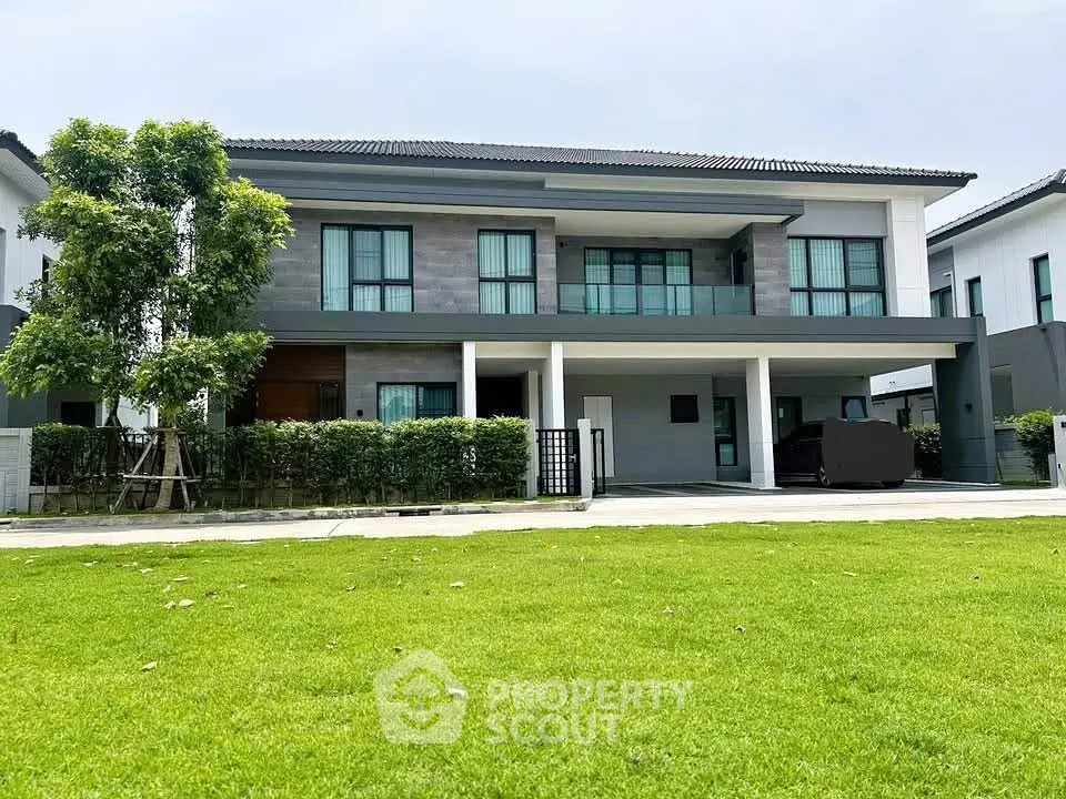 Modern two-story house with spacious lawn and contemporary design.