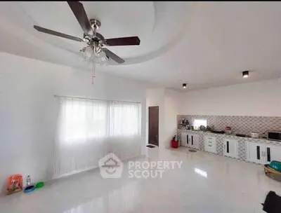 Spacious open-layout kitchen with modern ceiling fan and ample natural light.