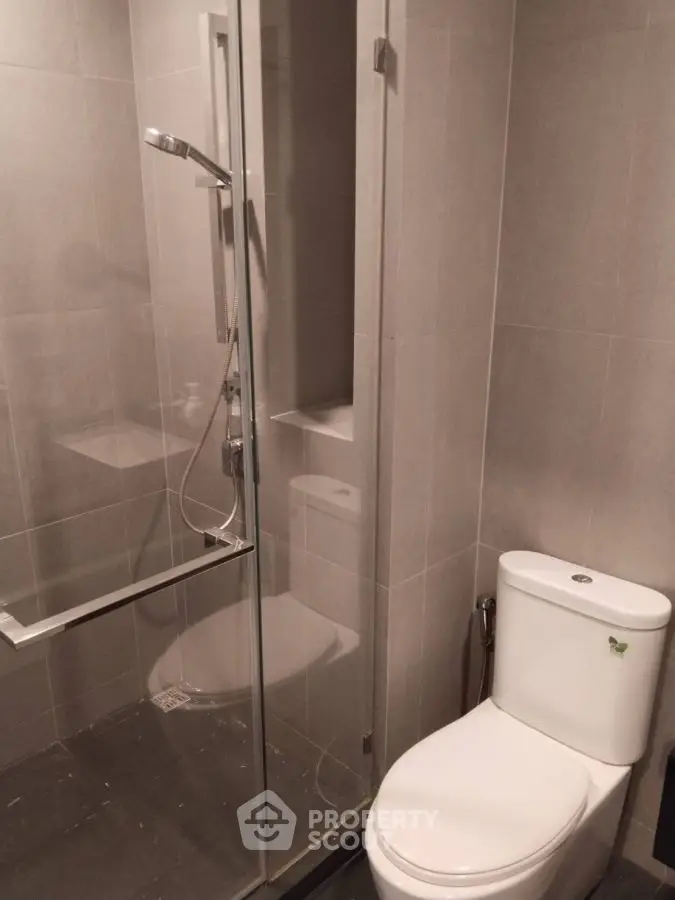 Modern bathroom with sleek shower and toilet in minimalist design.