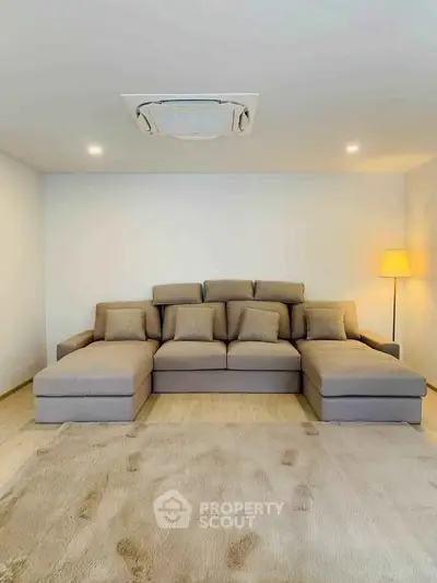 Spacious living room with modern sectional sofa and cozy lighting