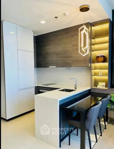 Modern kitchen with sleek design, featuring an island and stylish lighting.