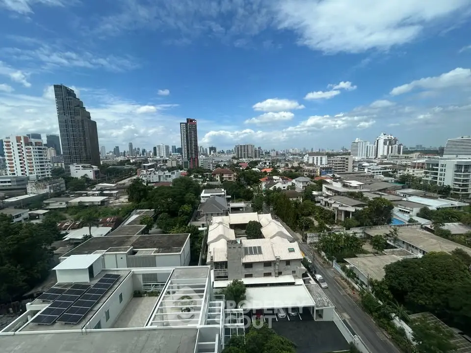 Stunning cityscape view from a high-rise building showcasing urban skyline and residential areas under a clear blue sky.