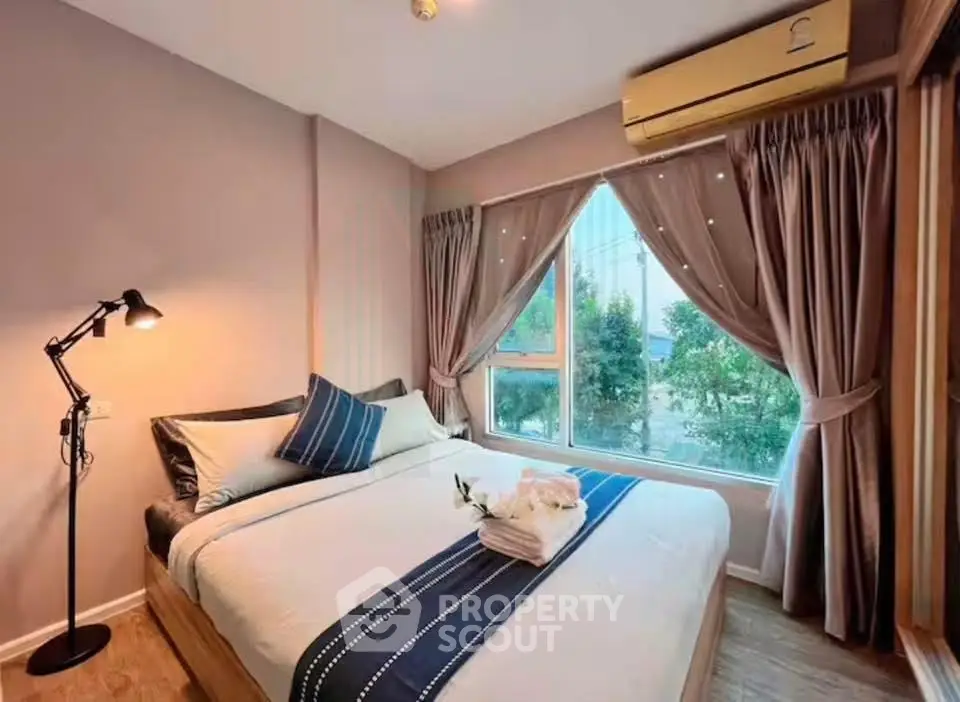 Cozy bedroom with large window and elegant decor in modern apartment