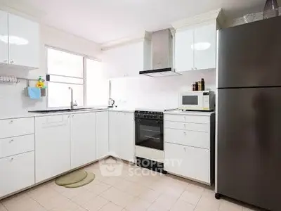 Modern kitchen with sleek white cabinets and stainless steel appliances